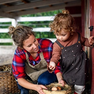 a mother and daughter collecting eggs