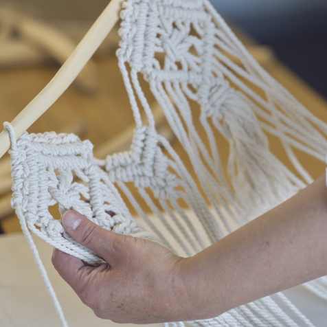 woman weaving using yarn